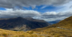 Mountains under heavy cloud with a break of blue sky beyond