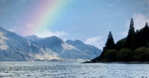A rainbow arching over a calm lake after rain